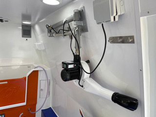 Small ambulance interior showcasing a blue floor and various medical supplies arranged for emergency use.